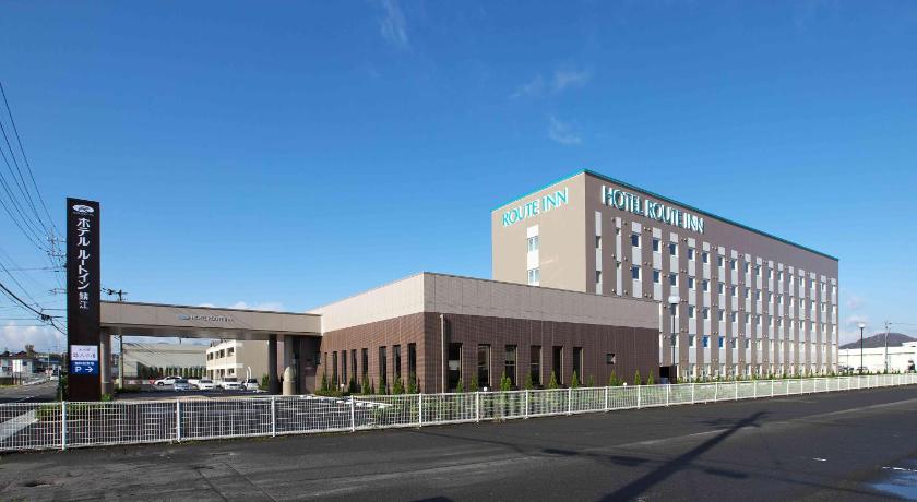 a tall building with a clock on the side of it, Hotel Route Inn Sabae Kokudou 8Gou in Fukui