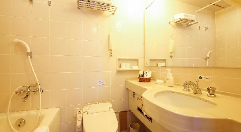 a white toilet sitting next to a sink in a bathroom, Tokushima Grandvrio Hotel in Tokushima