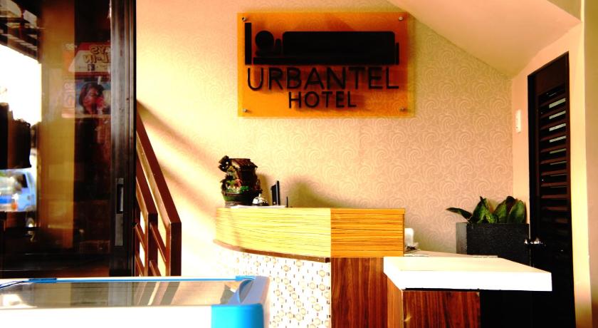 a cat sitting on top of a wooden table, Urbantel Hotel in Lucena