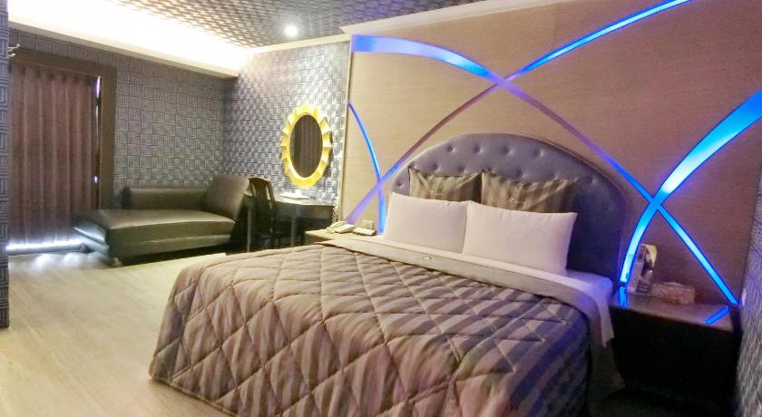 a bedroom with a bed and a lamp, Full Moon Boutique Motel in Hsinchu