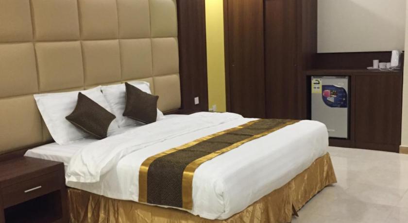 a hotel room with a bed and a desk, تاج الخليج للشقق المخدومة in Dammam