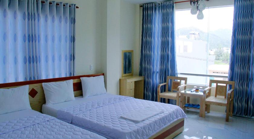a hotel room with two beds and a television, Yen Vy 32 Hotel and Pub in Quy Nhon (Binh Dinh)