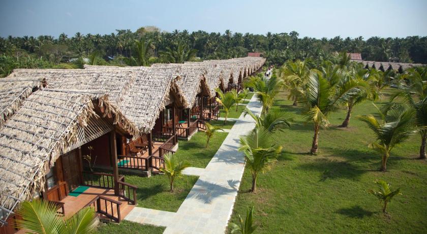 a patio area with tables, chairs and umbrellas, Symphony Palms Beach Resort - Havelock Island and Spa in Andaman and Nicobar Islands