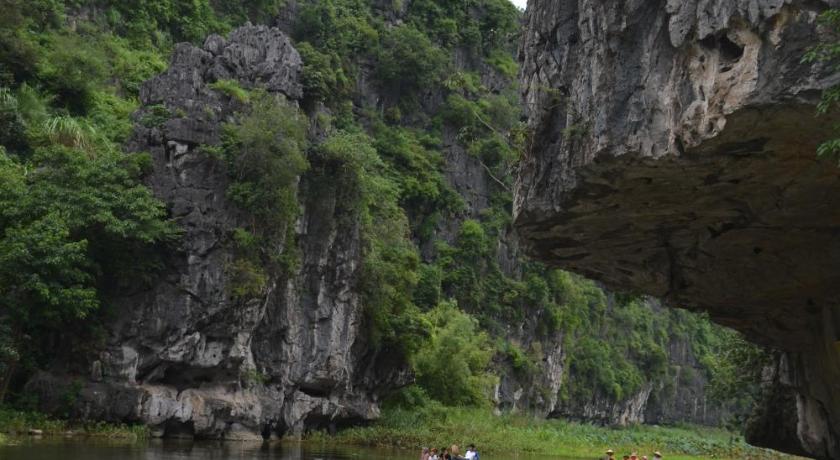 a person on a boat on a river near a body of water, Tam Coc Smile Homestay in Ninh Bình