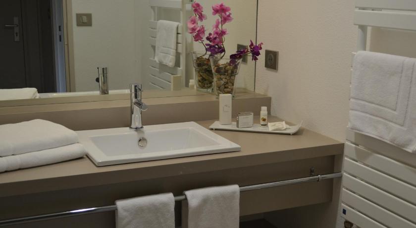a bathroom with a sink, mirror, and towels, Hotel de Guyenne in Bordeaux