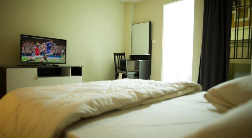 a bedroom with a bed and a television, The Suvarnabhumi Apartment in Bangkok