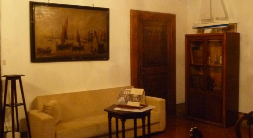 a living room filled with furniture and a painting on the wall, Time Out in Pisa