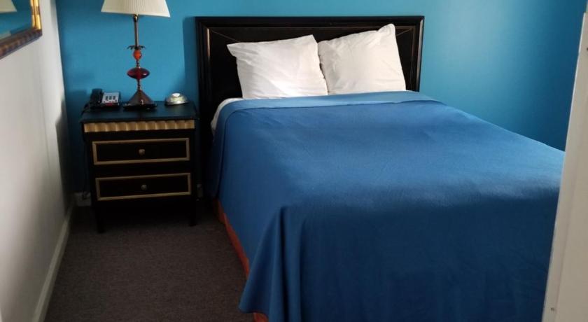 a bedroom with a bed and a lamp, Ramada by Wyndham Williston in Williston (ND)