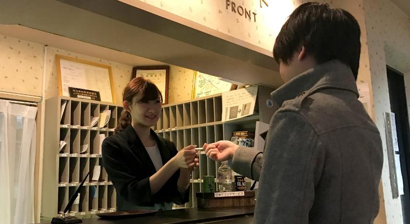 a man and a woman looking at a glass of wine, E Hotel Warabi in Kawaguchi