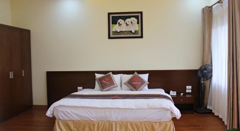 a bed with a white bedspread and pillows on it, Hanvet Hotel Do Son in Haiphong