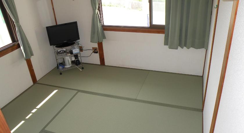 a living room with a tv and a window, Business Hotel Minshuku Minato in Tokushima