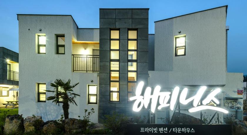 a large white building with a mural on the side of it, Happiness Pension in Jeju
