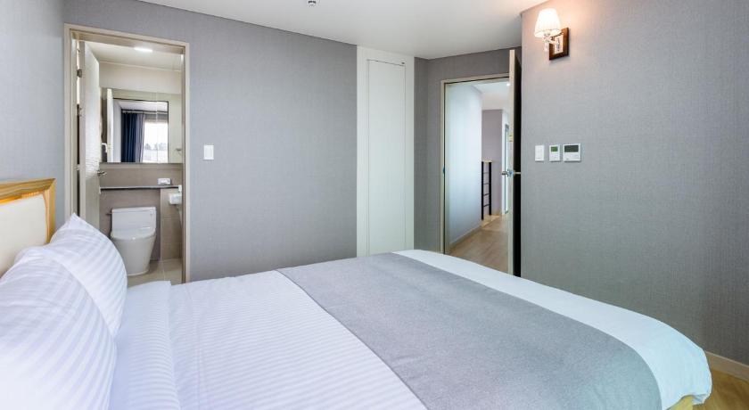 a hotel room with a bed and a mirror, Happiness Pension in Jeju