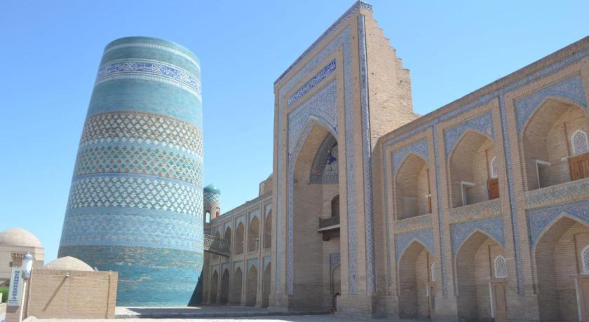 a large blue building with a clock on the front of it, Orient Star Khiva Hotel- Madrasah Muhammad Aminkhan in Khiva