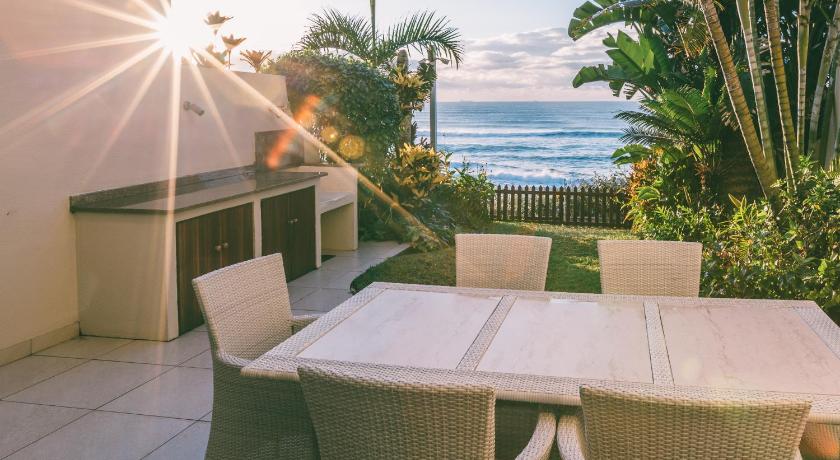 a table with chairs and a table cloth, Bronze Beach Villa in Durban
