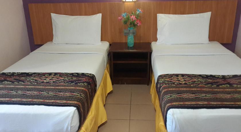 two beds in a room with two lamps, Raja Inn in Miri