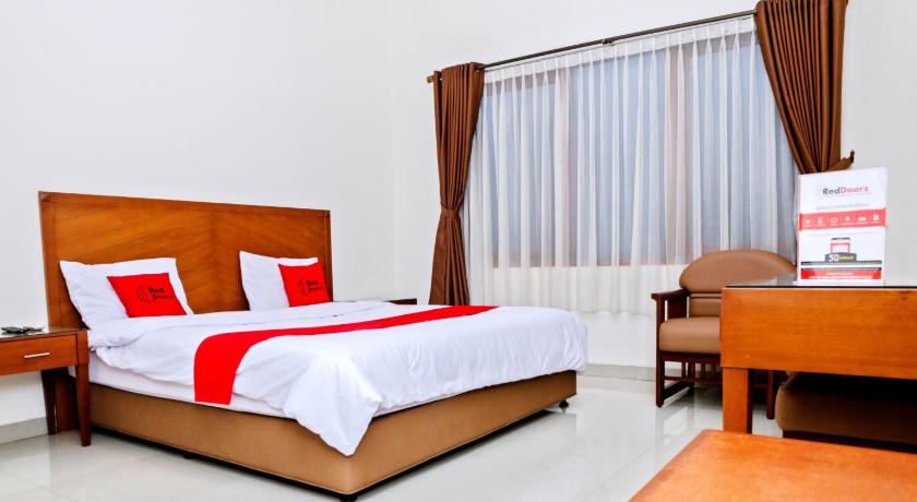 a hotel room with a bed and a desk, Residences by RedDoorz near Rumah Mode in Bandung