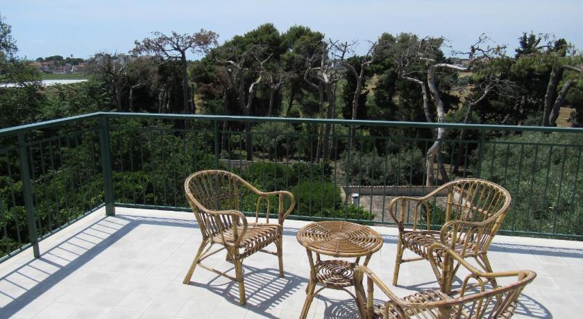 a patio area with chairs, tables and umbrellas, Villa Marta in Taranto