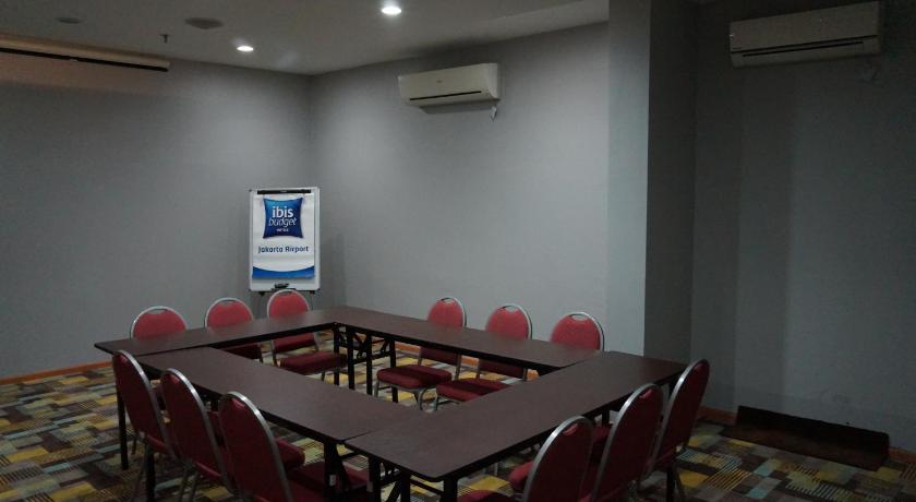 a room with a table, chairs, and a television, Ibis Budget Jakarta Airport in Jakarta