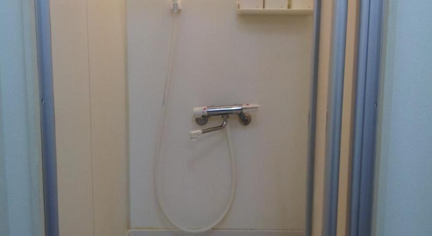 a shower stall with a toilet and a shower curtain, Hotel Taiyo in Osaka