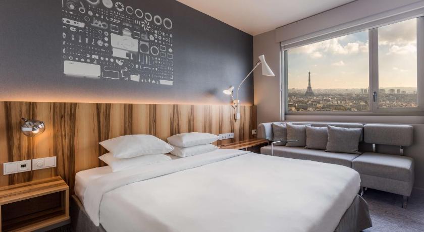 a hotel room with a large bed and a large window, Hyatt Regency Paris Etoile in Paris