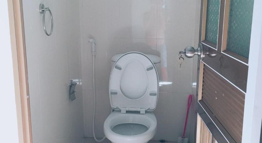 a white toilet sitting in a bathroom next to a window, Hung Anh Homestay in Ninh Bình