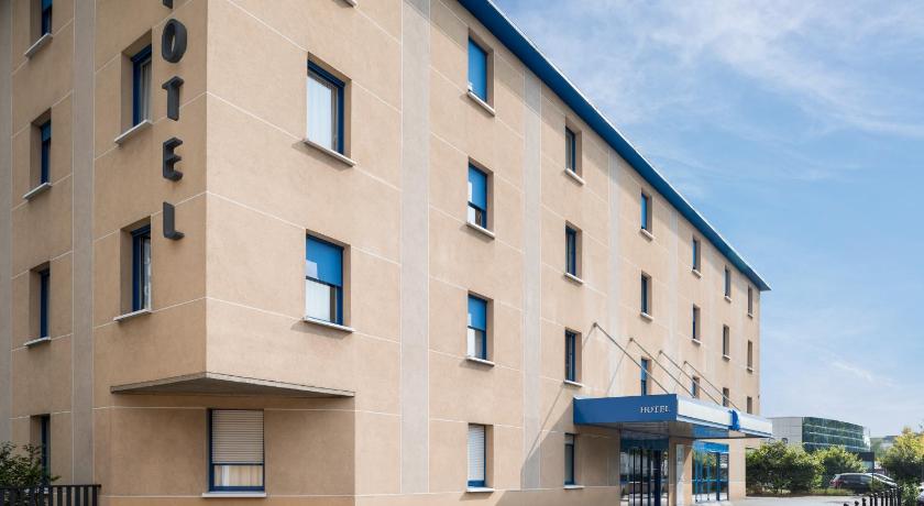 a large building with a blue roof and windows, ibis budget Bobigny Pantin in Paris