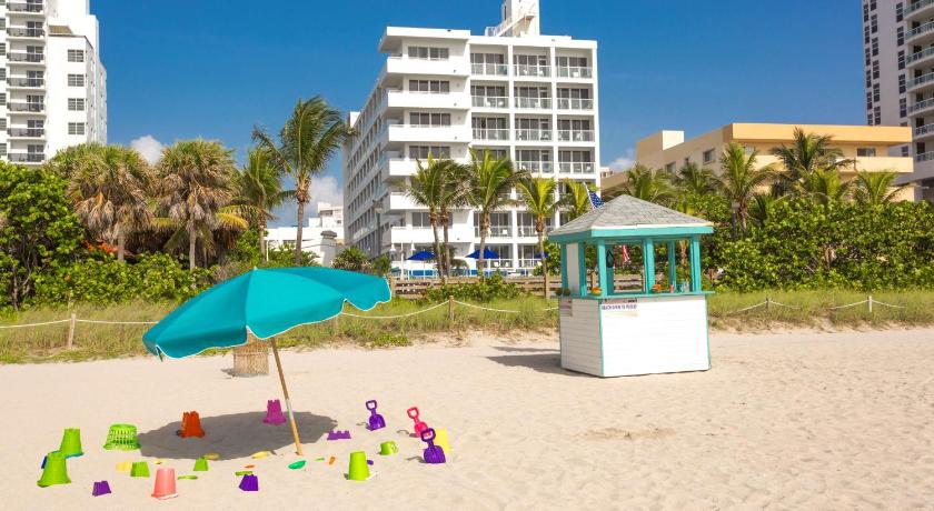 a beach area with a beach umbrella and chairs, Best Western Plus Atlantic Beach Resort in Miami Beach (FL)