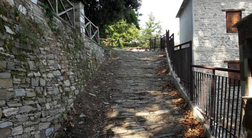 a wooden walkway leading to a stone wall, Spiros Apartments Pelion in Kalamaki