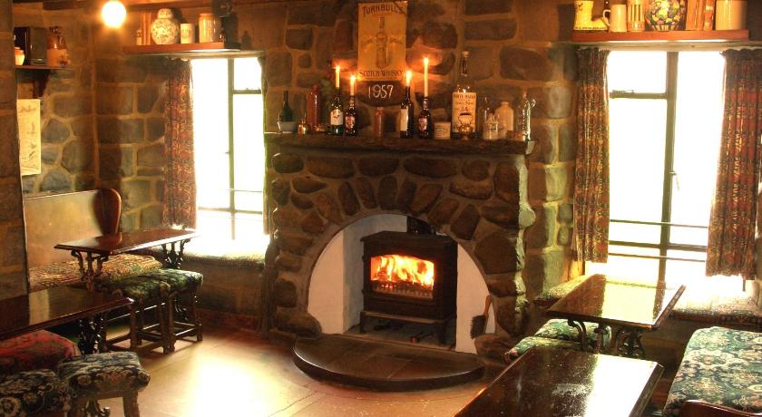 a living room with a fireplace and a fire place, Cuilfail Hotel in Clachan-Seil