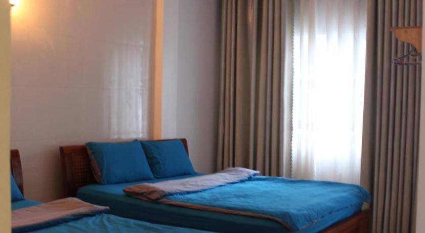 two beds in a room with a blue wall, DaLat Sky Hostel in Dalat
