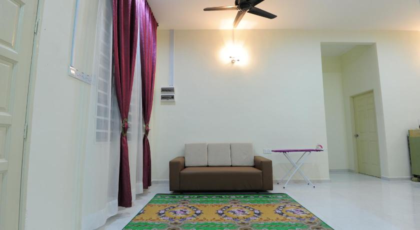 a living room with a couch and a rug, Luqman Guesthouse in Kangar