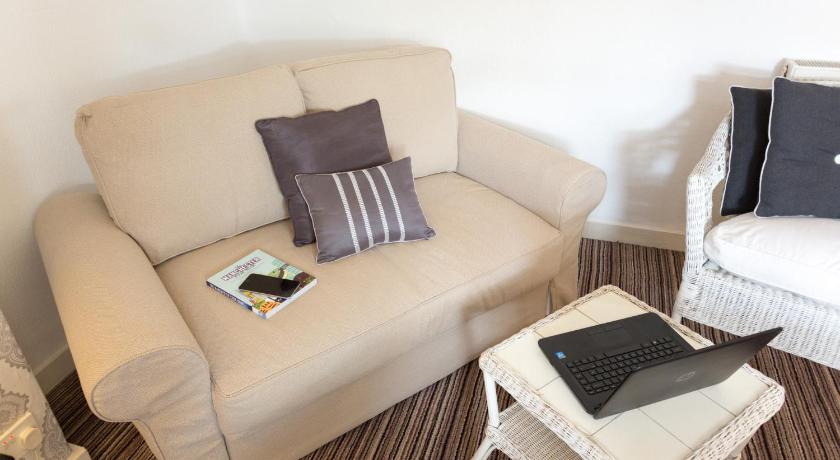 a living room with a couch and a laptop, The Ascott in Manchester