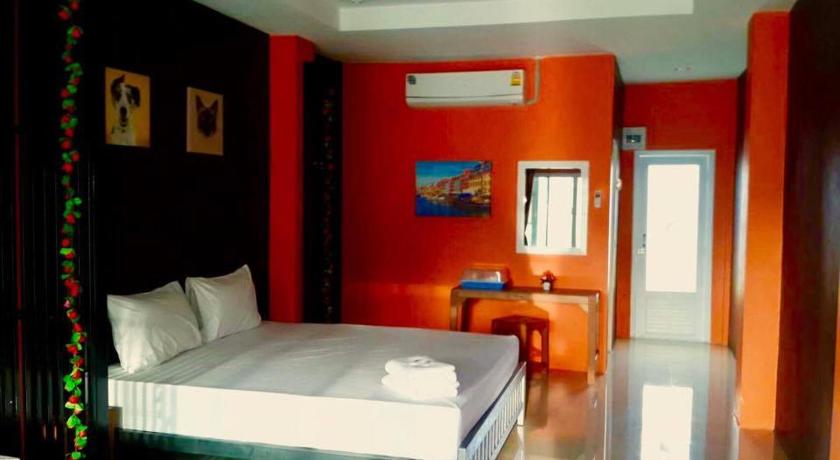 a bedroom with a bed and a painting on the wall, Na Kabin Resort in Prachinburi