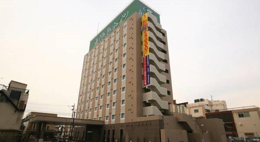 a large building with a large clock on top of it, Hotel Route Inn Koga Ekimae in Koga