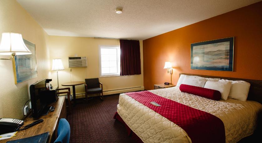 a hotel room with a bed, desk, and television, Days Inn by Wyndham Minot in Minot (ND)