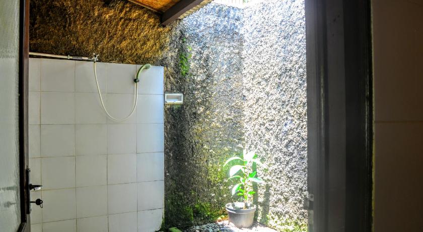 a bathroom with a toilet and a sink, Padangbai Beach Homestay in Bali