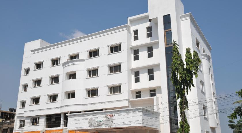 a large white building with a large window, Hotel Vijayentra in Pondicherry