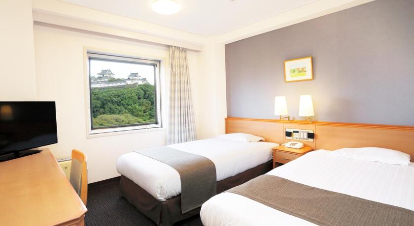 a hotel room with two beds and a television, Smile Hotel Wakayama in Wakayama