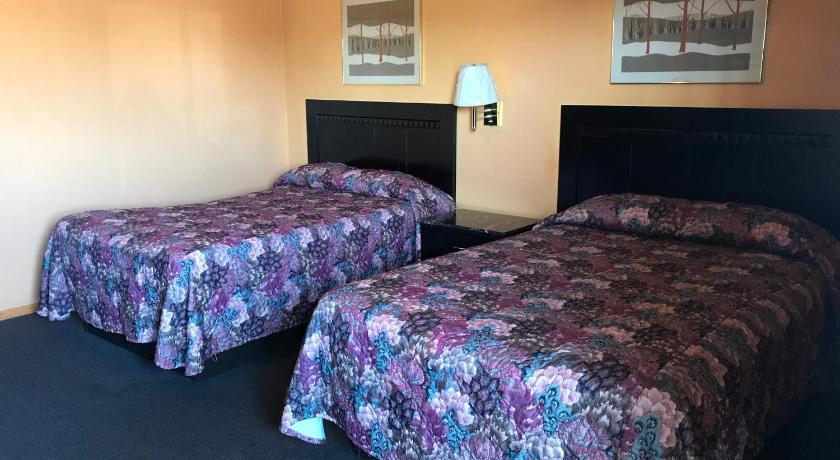 two beds in a hotel room with a blue wall, Pratt Budget Inn in Pratt (KS)