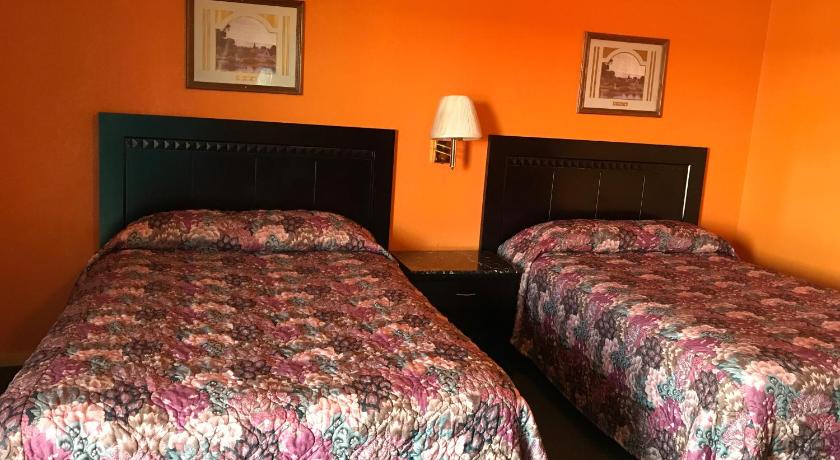 two beds in a room with two lamps on, Pratt Budget Inn in Pratt (KS)