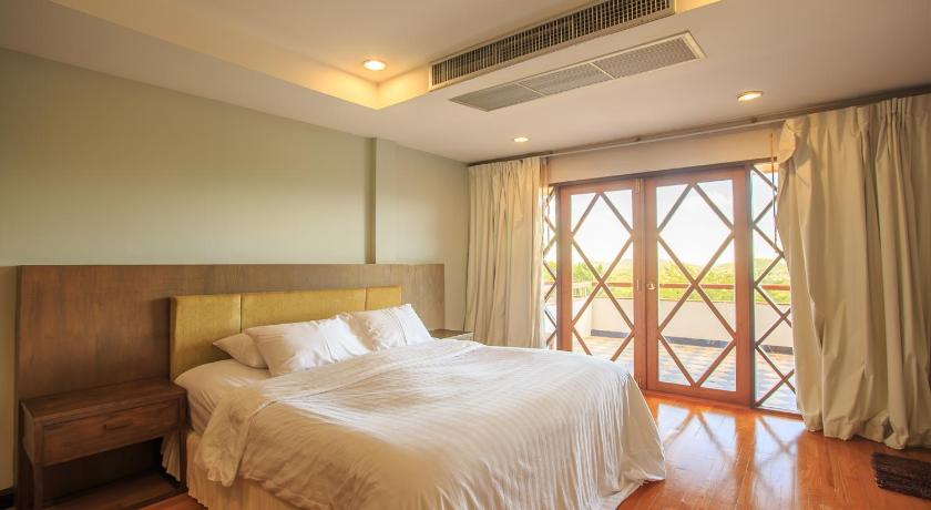 a bedroom with a bed and a window, Phuripimarn Penthouse in Khao Yai