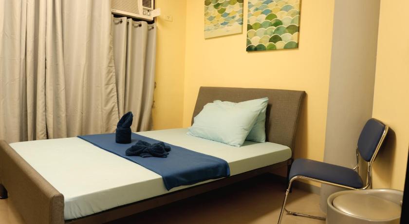 a bedroom with a blue and white bed and a blue and white chair, Transit Point Hostel - Mactan Cebu in Cebu