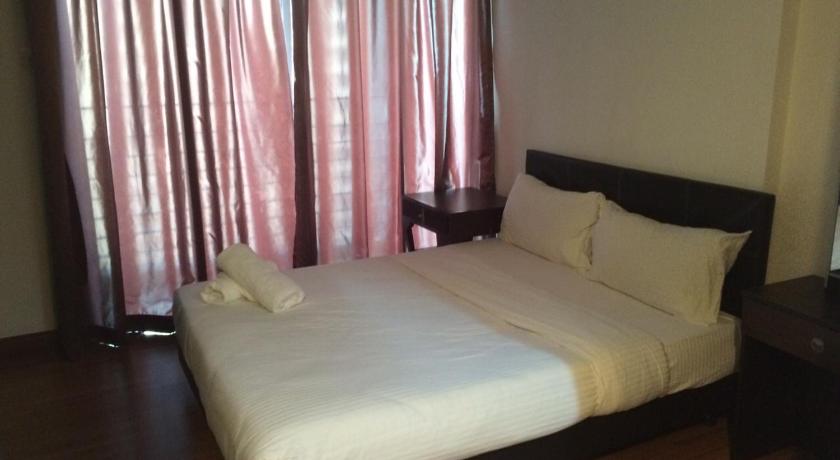a bed with a white comforter next to a window, Obsom Suites at Taragon KL in Kuala Lumpur