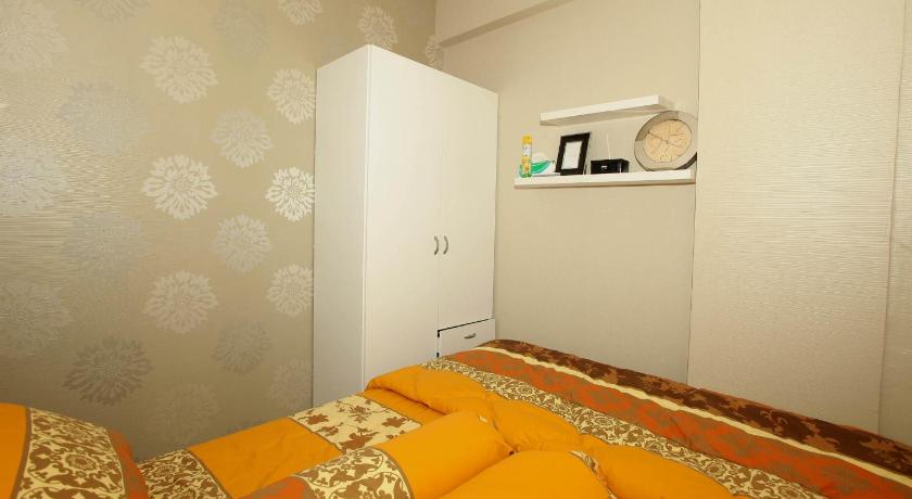 a bedroom with a bed and a television, apartemen puri park view in Jakarta