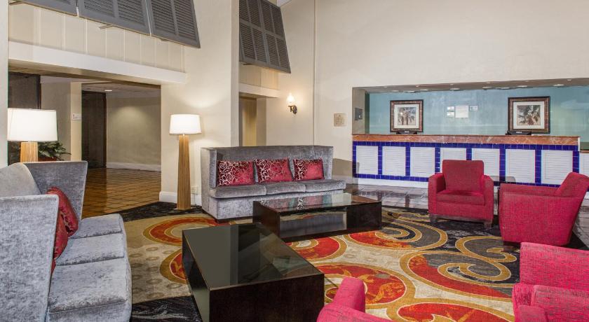 a living room filled with lots of furniture, Ramada by Wyndham West Palm Beach Airport in West Palm Beach (FL)