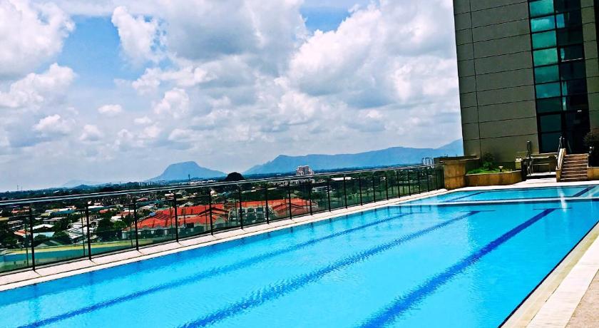 a swimming pool with a blue railing and a blue sky, Imperial Grand Suite  Apartment  (3 Bedroom) in Kuching