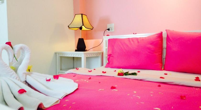 a bed room with a white bedspread and a pink bedspread, Ben's House in Krabi