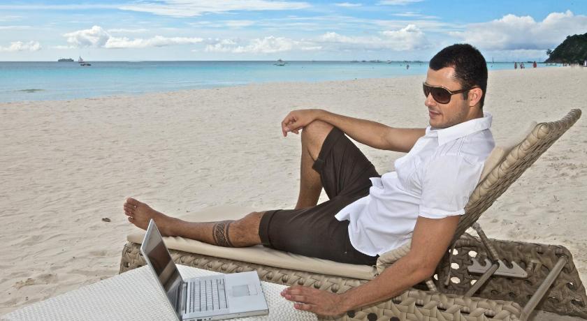 a man sitting on a bench in front of a beach, Estacio Uno - Boracay Lifestyle Resort in Boracay Island