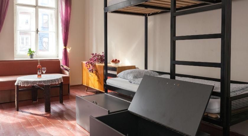 a room with a bed and a desk with a laptop on it, Hostel Fleda in Brno